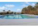 A large, inviting swimming pool with a blue-trimmed edge, surrounded by a spacious deck and lush greenery at 865 Summer Starling Pl., Myrtle Beach, SC 29577