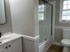 Modern bathroom with a sliding glass door shower, white vanity, and neutral color scheme at 876 S Clay Field Rd, Johnsonville, SC 29555