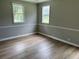 Bedroom with light-colored walls, white trim, hardwood floors, and two large windows at 876 S Clay Field Rd, Johnsonville, SC 29555