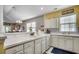Charming kitchen with white cabinets, tile backsplash, and modern appliances with view of adjacent living area at 901 West Port Dr. # 712, North Myrtle Beach, SC 29582
