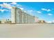 Large beachfront building with many floors, balconies, and direct access to the sandy shoreline at 9400 Shore Dr. # 411, Myrtle Beach, SC 29572
