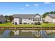Waterfront backyard with lush lawn, a patio set, grill, and a calming canal at 9466 Old Palmetto Dr., Murrells Inlet, SC 29576