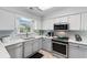 Updated kitchen with stainless steel appliances, quartz countertops, and gray lower cabinets at 9466 Old Palmetto Dr., Murrells Inlet, SC 29576