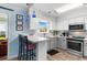 Well-lit kitchen with white cabinets, a breakfast bar, stainless steel appliances, and stylish pendant lighting at 9466 Old Palmetto Dr., Murrells Inlet, SC 29576
