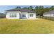 Spacious backyard with black metal fencing and a new house with white siding and black roof at Simpson Creek Dr., Loris, SC 29569