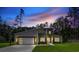 Beautiful home with a modern design and stone accents, complemented by a vibrant sunset and manicured lawn at 1028 Colette Ct, Conway, SC 29526