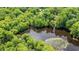 Aerial view showing a secluded property surrounded by a lush green forest and a dark lake at 1032 Chelsey Circle, Conway, SC 29526