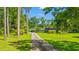 Long driveway leading to a charming home with mature trees and green lawn at 1032 Chelsey Circle, Conway, SC 29526