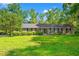 Charming brick home featuring a lush front lawn, mature trees, and manicured hedges at 1032 Chelsey Circle, Conway, SC 29526