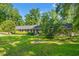 Charming brick home featuring a lush front lawn, mature trees, and manicured hedges at 1032 Chelsey Circle, Conway, SC 29526