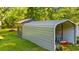 Property's storage shed and vehicle shelter surrounded by a green lawn and trees at 1032 Chelsey Circle, Conway, SC 29526