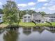 Exterior view of a backyard with a lake, green grass, black fence, and patio furniture on the covered porch at 1048 Meadowoods Dr., Murrells Inlet, SC 29576