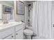 Bright bathroom with white fixtures, shower with curtain and framed art at 1048 Meadowoods Dr., Murrells Inlet, SC 29576
