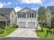Two-story home featuring a concrete driveway, two-car garage and a well-manicured lawn under a partly cloudy blue sky at 1048 Meadowoods Dr., Murrells Inlet, SC 29576