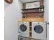 Well-organized laundry room with brick accent wall, wooden shelves, and front-loading washer and dryer at 1048 Meadowoods Dr., Murrells Inlet, SC 29576