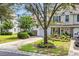 View of the townhome, driveway, and a mature tree shading a landscaped yard at 1057 Stanton Pl. # 1057, Myrtle Beach, SC 29579