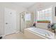 Bathroom with a soaking tub, glass-enclosed shower, and decorative chandelier at 107 Fox Den Dr., Murrells Inlet, SC 29576