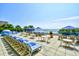 Outdoor seating area with lounge chairs and tables under blue umbrellas, overlooking the ocean at 1105 S Ocean Blvd. # 330, Myrtle Beach, SC 29577