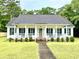 Charming single-story home with white siding, dark shutters, and a welcoming front porch at 112 Robin Dr., Georgetown, SC 29440