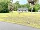 Charming single-story home featuring a large green lawn, mature palm trees, and a white picket fence at 112 Robin Dr., Georgetown, SC 29440