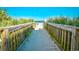 Beach access pathway with wood railings and lush greenery leading to a sandy beach at 1200 S Ocean Blvd. # 20506, Myrtle Beach, SC 29577