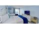 Well-lit bedroom with two beds, dresser, TV, and calming blue walls at 1200 S Ocean Blvd. # 20506, Myrtle Beach, SC 29577