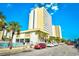 Exterior view of a resort near the beach and pool, enhanced with palm trees and clear blue sky at 1200 S Ocean Blvd. # 20506, Myrtle Beach, SC 29577