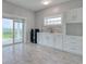 Bright kitchenette featuring white cabinets, stone backsplash, tile floors, and a door to the outside at 125 Oak Bay Dr., Georgetown, SC 29440