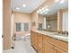 Bright bathroom boasts a granite countertop, dual sinks, and a large mirror at 128 Knotty Pine Way, Murrells Inlet, SC 29576
