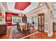 The dining room has a vibrant red ceiling, seating for eight, and hardwood floors at 128 Knotty Pine Way, Murrells Inlet, SC 29576