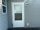 Exterior view of the back door with gray siding, and a window, providing access to the backyard at 140 Blue Pride Dr., Loris, SC 29569