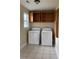 Bright laundry room equipped with washer, dryer, and wood cabinets for storage and organization at 140 Blue Pride Dr., Loris, SC 29569