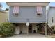 Charming beach house with unique pink shutter accents and a spacious ground level covered parking area at 147 Weatherboard Ct., Pawleys Island, SC 29585
