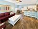 Open-concept living room featuring wood floors, a red sofa, and adjacent dining and kitchen areas at 147 Weatherboard Ct., Pawleys Island, SC 29585