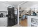 Kitchen with black fridge leading to living area with hardwood floors and light blue armchairs at 1710-C Edge Dr., North Myrtle Beach, SC 29582
