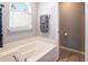 Relaxing bathroom with a soaking tub, tiled floors, and a large window providing natural light at 174 Edward Ave., Murrells Inlet, SC 29576