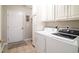 Laundry room with modern washer and dryer units, tile floors and a door to outside at 174 Edward Ave., Murrells Inlet, SC 29576
