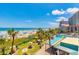 Aerial view showcasing beach with colorful umbrellas, palm trees, pool, and picnic tables at 201 74Th Ave. N # 2333, Myrtle Beach, SC 29572