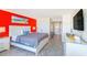 Relaxing bedroom featuring red accent wall, dresser, television and bathroom access at 201 74Th Ave. N # 2333, Myrtle Beach, SC 29572
