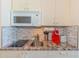 Modern kitchenette features granite counters, microwave, sink, and cooktop for convenient meal prep at 201 74Th Ave. N # 2333, Myrtle Beach, SC 29572