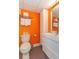 Bathroom featuring a toilet, vanity, and bright orange walls at 201 74Th Ave. N # 2740, Myrtle Beach, SC 29572
