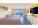 Bright condo bedroom featuring yellow walls, a queen sized bed, ocean view and TV at 201 74Th Ave. N # 2740, Myrtle Beach, SC 29572