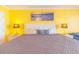 Relaxing bedroom with bright yellow walls, lamps and ocean themed wall art at 201 74Th Ave. N # 2740, Myrtle Beach, SC 29572