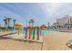 Resort pool area featuring colorful play structure, lounge chairs, and palm trees, creating a Gathering-friendly oasis at 201 74Th Ave. N # 2740, Myrtle Beach, SC 29572