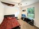 Bright bedroom with a TV, ceiling fan, and a large window overlooking the neighborhood at 2021 Loblolly St., Georgetown, SC 29440