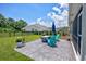 Large backyard boasts a stone patio with chairs, manicured lawn, and a fenced perimeter at 204 Kinross Ct., Little River, SC 29566