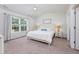 Comfortable bedroom with a white bed, ceiling fan, two side tables, and bright natural lighting at 204 Kinross Ct., Little River, SC 29566