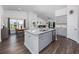 Open-concept kitchen and dining area featuring granite counters, wood flooring, and stainless steel appliances at 204 Kinross Ct., Little River, SC 29566