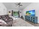 Inviting living room features a plush sofa, large TV, a ceiling fan, and patio access at 204 Kinross Ct., Little River, SC 29566