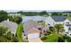 Aerial shot of home featuring a brick facade, lush landscaping, and a lake in the distance at 2210 Haystack Way, Myrtle Beach, SC 29579